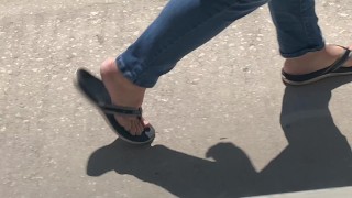 Female friend feet in flip flops coming to see me in public, in motion view