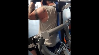 Tattooed muscular guy sweating in the gym 