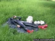 Preview 1 of Rubber Girl Full in Black Latex Catsuit and Mask Plays with herself Outdoor in a Meadow - Part 4