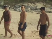 Preview 2 of Sensual Tanned Dark Haired Hunk Takes Two Dicks On The Sand!