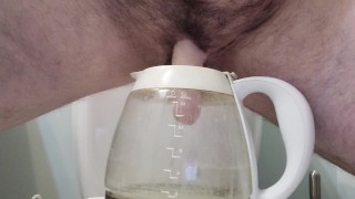 A trans guy pees in a graduated coffee jug