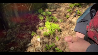 Bearded guy pissing in the forest. A man relieves himself in nature