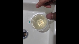 Boy close up Peeing on a cup, Trowing pee away then peeing again on the cup