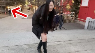 A Japanese woman pees in the snow outdoors.