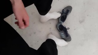 a young skater shows off his white socks and sneakers