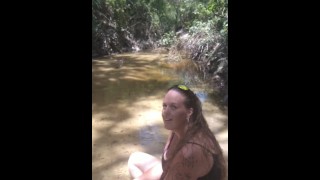 Cute long hair girl on her knees looking for shells to collect in popular spring creek