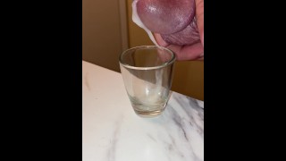 Collecting my cum in a shot glass, breathing heavy and moaning squeezing it out of my dick