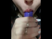 Preview 2 of A cute girl sucks on a purple toy.